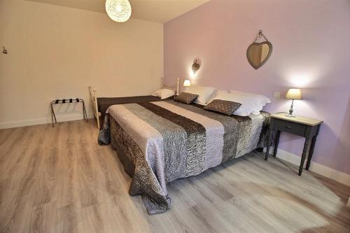 a bedroom with a bed and a table and lamp at Logis du Lièvre d'or in Montbazon