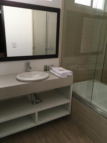 a bathroom with a sink and a mirror and a tub at Hotel Villa Blanca in Popayan
