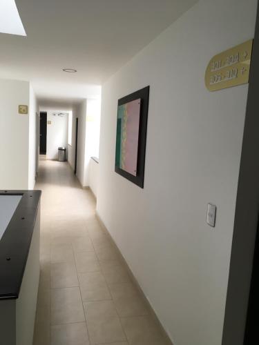a hallway with white walls and a picture on a wall at Hotel Villa Blanca in Popayan