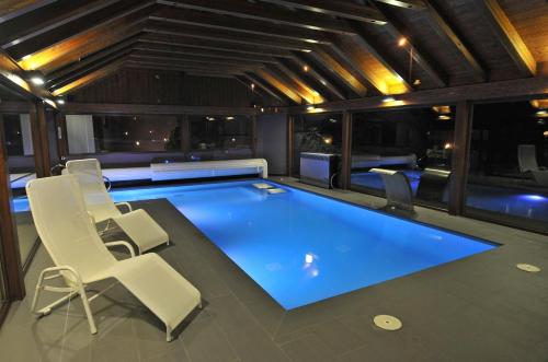 a swimming pool in a room with chairs and tables at Apartamentos Pessets Adelaida in Sort