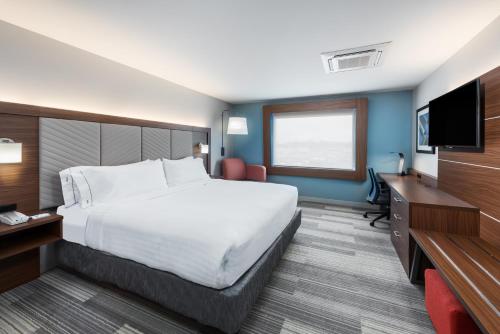 a hotel room with a large bed and a flat screen tv at Holiday Inn Express & Suites West Plains Southwest by IHG in West Plains