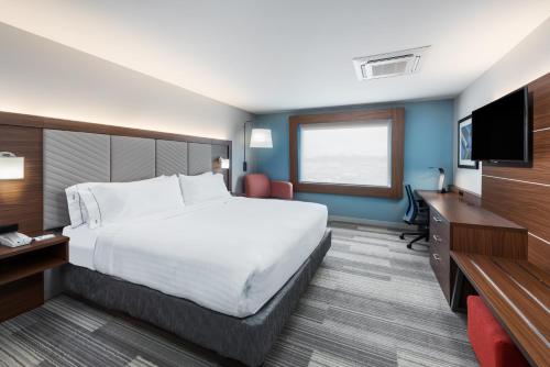 a hotel room with a large bed and a flat screen tv at Holiday Inn Express & Suites West Plains Southwest, an IHG Hotel in West Plains