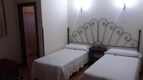 two twin beds in a room with white walls at Posada Ana Ponce in Sierra de Yeguas