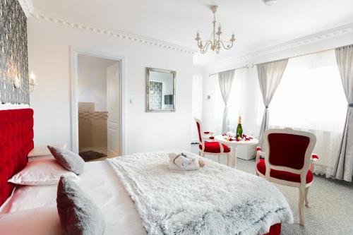 a bedroom with a bed and a table and chairs at Pensiunea Avy in Haţeg