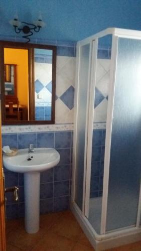 ein Bad mit einem Waschbecken und einem Spiegel in der Unterkunft Posada Ana Ponce in Sierra de Yeguas
