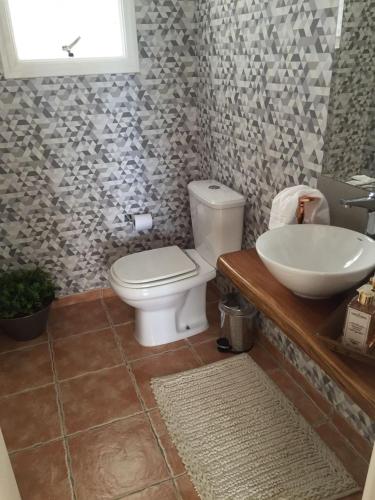 a bathroom with a toilet and a sink at Vila de Charme Suítes in Campos do Jordão