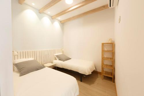 1 dormitorio con 2 camas y estante para libros en Ganexa Home, en Zarautz