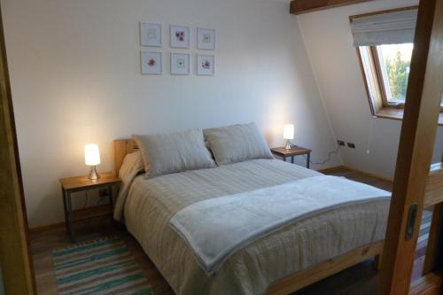 een slaapkamer met een bed en twee lampen op tafels bij Edificio Guadalauquen in Valdivia