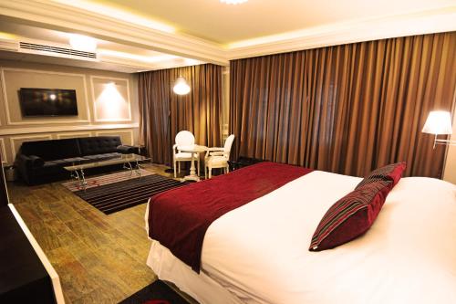 a hotel room with a bed and a living room at Hotel Sommelier Boutique in Santiago