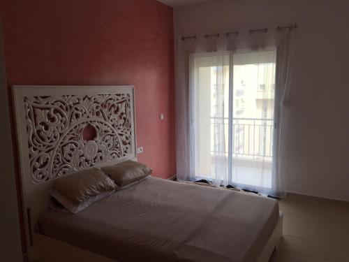 - une chambre avec un lit blanc et une fenêtre dans l'établissement Appartement Les quais verts, à Oujda