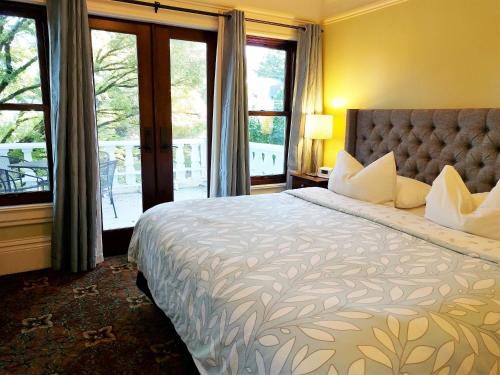 a bedroom with a large bed and a balcony at Evermore Guesthouse in Portland