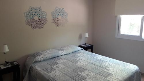 a bedroom with a bed and two lamps and a window at Cabañas La María Josefa in San Rafael