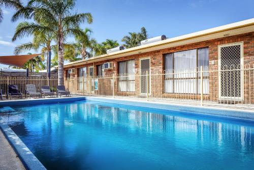 a swimming pool in front of a building at Allambi Holiday Apartments in Lakes Entrance