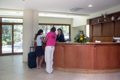 three women standing at a reception desk in a waiting room at Hotel Portonuovo in Vieste