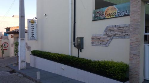 a building with a sign on the side of it at Pousada Palmares in Cabo Frio