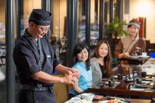 a man standing in a restaurant preparing food at Queena Plaza Hotel in Yongkang