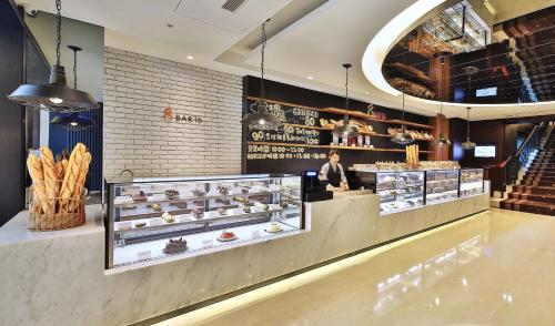 a bakery with a man standing behind a counter with pastries at Queena Plaza Hotel in Yongkang