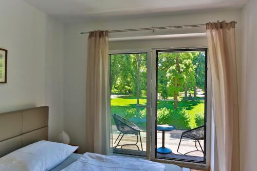 a bedroom with a bed and a sliding glass door at Parksuites Apartments Graz in Graz