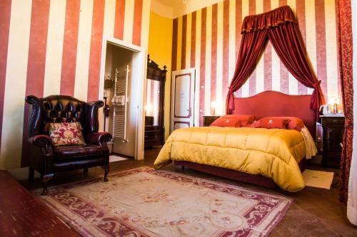 a bedroom with a bed and a chair at Relais Villa Al Vento in Incisa in Valdarno