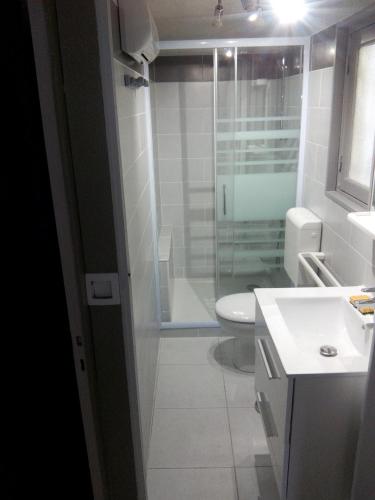 une salle de bain avec toilettes et douche en verre dans l'établissement Maison JMB, à Royan
