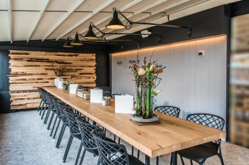 a long table with chairs and a vase of flowers at Apart! & Moment! in De Haan