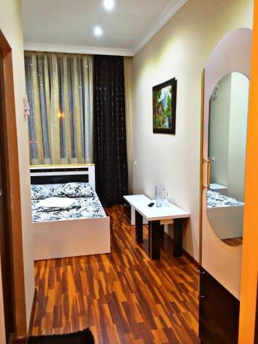 a room with a bed and a sink and a mirror at Golden House in Batumi