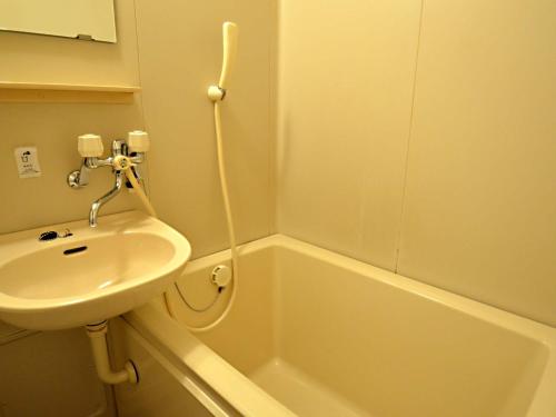 y baño con lavamanos, bañera y lavamanos. en Hotel Tamanoya, en Saijo