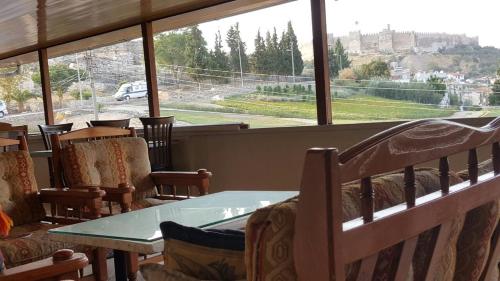 a restaurant with a table and chairs and a large window at Ephesus Selcuk Castle View Suites in Selçuk