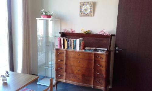 a glass cabinet and a dresser with books on it at B&B Cafisu in Paceco