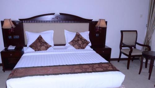 a bedroom with a large bed with a wooden headboard at Debredamo Hotel in Addis Ababa