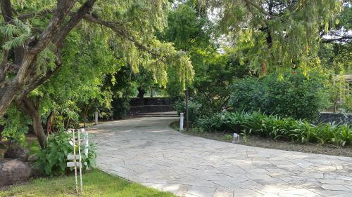 a walkway in a park with trees and plants at The Meadows Resort and Spa in Aurangabad