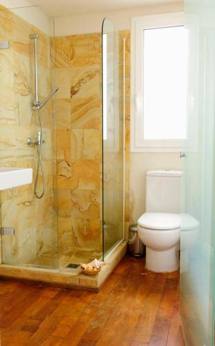 a bathroom with a toilet and a glass shower at Apartamento con terraza in Tarifa