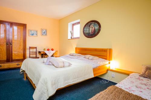 a bedroom with two beds and a clock on the wall at Penzion u lípy in Suchdol nad Lužnicí