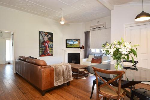 a living room with a couch and a table at Linda's Cottage @ the Hunter in Cessnock