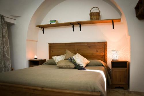 a bedroom with a large bed with a wooden headboard at B&B Masseria del Marchese in Castellana Grotte
