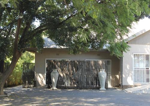 three white vases sitting in front of a house at Fin and Feather Guest Lodge in Boksburg