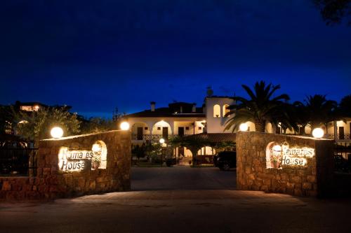 a night view of a villa with lights on a fence at Kamares House Apartments & Studios in Vourvourou