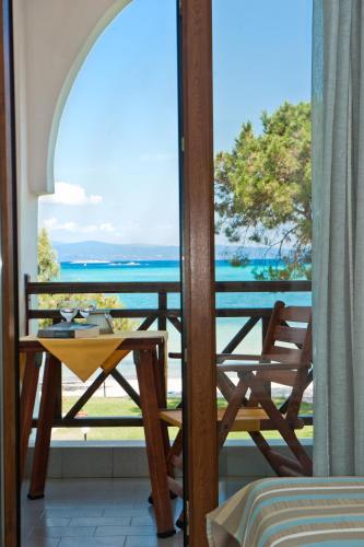 a balcony with a table and a view of the ocean at Kamares House Apartments & Studios in Vourvourou