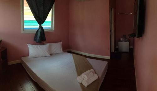 a small bed in a room with a window at Se'sun Amphawa in Amphawa