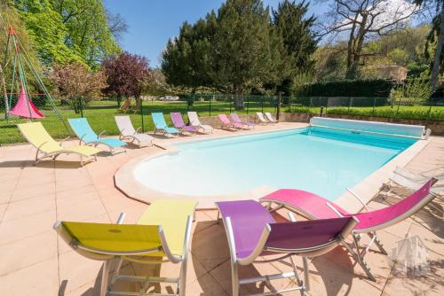 eine Gruppe Stühle und ein Pool in der Unterkunft Le Relais Des Dames in Neuville-sur-Saône