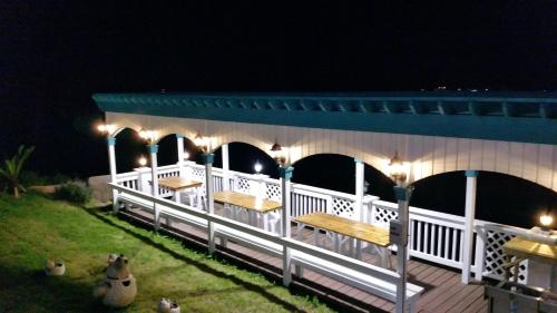a deck with benches and lights at night at Jeju the Ocean Hill Pension in Seogwipo