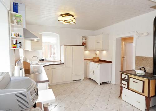 a kitchen with white cabinets and a white refrigerator at Feriendomizil Erzgebirge in Marienberg