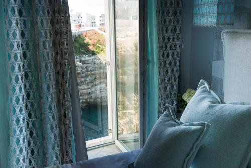 a window with blue curtains and pillows in a room at San Michele Suite in Polignano a Mare