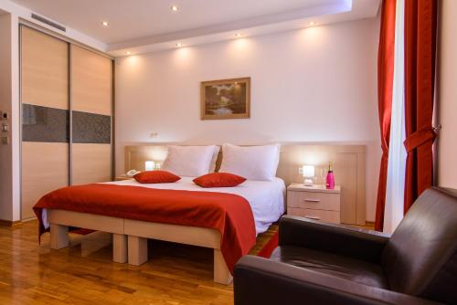 a bedroom with a bed with a red blanket at Heritage Hotel Vila Sikaa in Trogir