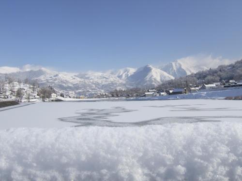 a view of a frozen lake with mountains in the background at Auberge Le Cabaliros in Argelès-Gazost