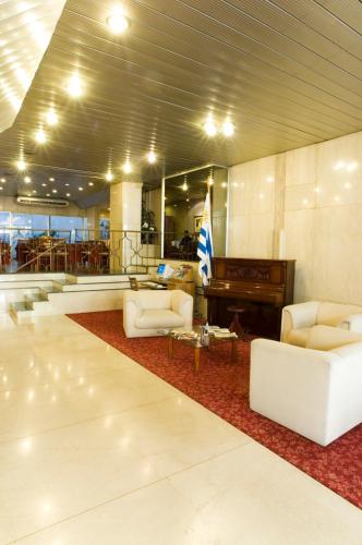 a lobby with a piano and couches and a rug at Hotel Europa in Montevideo