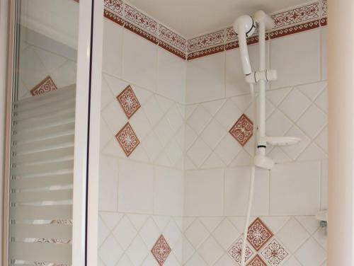 a shower in a bathroom with white tiles at Gite en Alsace in Mutzig