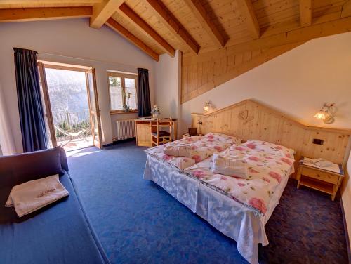 a bedroom with a bed and a large window at Hotel Negritella in Folgarida