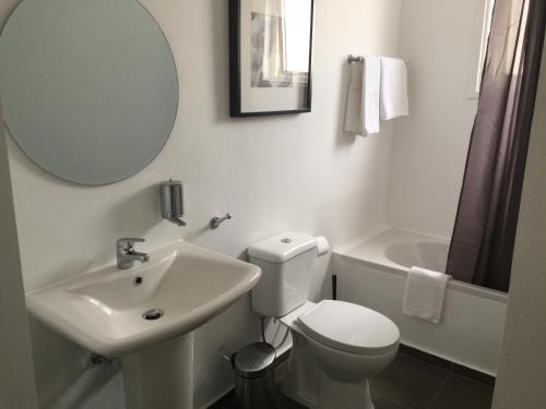 a bathroom with a toilet and a sink and a mirror at Pasithea Holiday Apartments in Larnaka