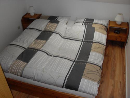 - un lit avec une couette en noir et blanc dans l'établissement Ferienwohnung Waldblick, à Braunlage